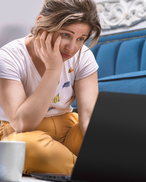 A woman looking frustrated at her computer.