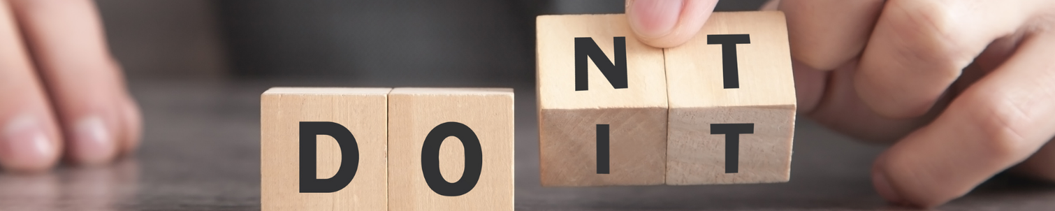 Male in a suit, lifting letter blocks that spell 'do it' and 'don't do it'.