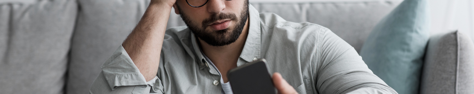 A male looking at his phone anxiously