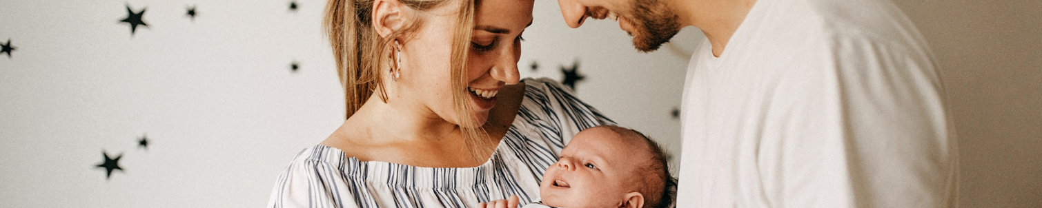 Parents holding their new-born baby at home.