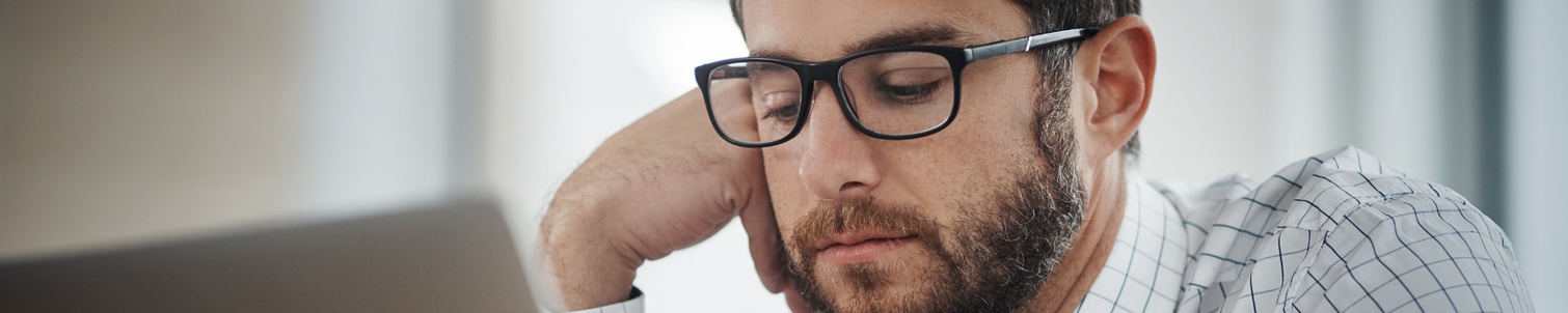 A male employee looking bored at work, longing for change.