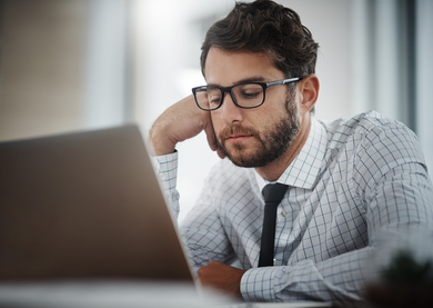 A male employee looking bored at work, longing for change.